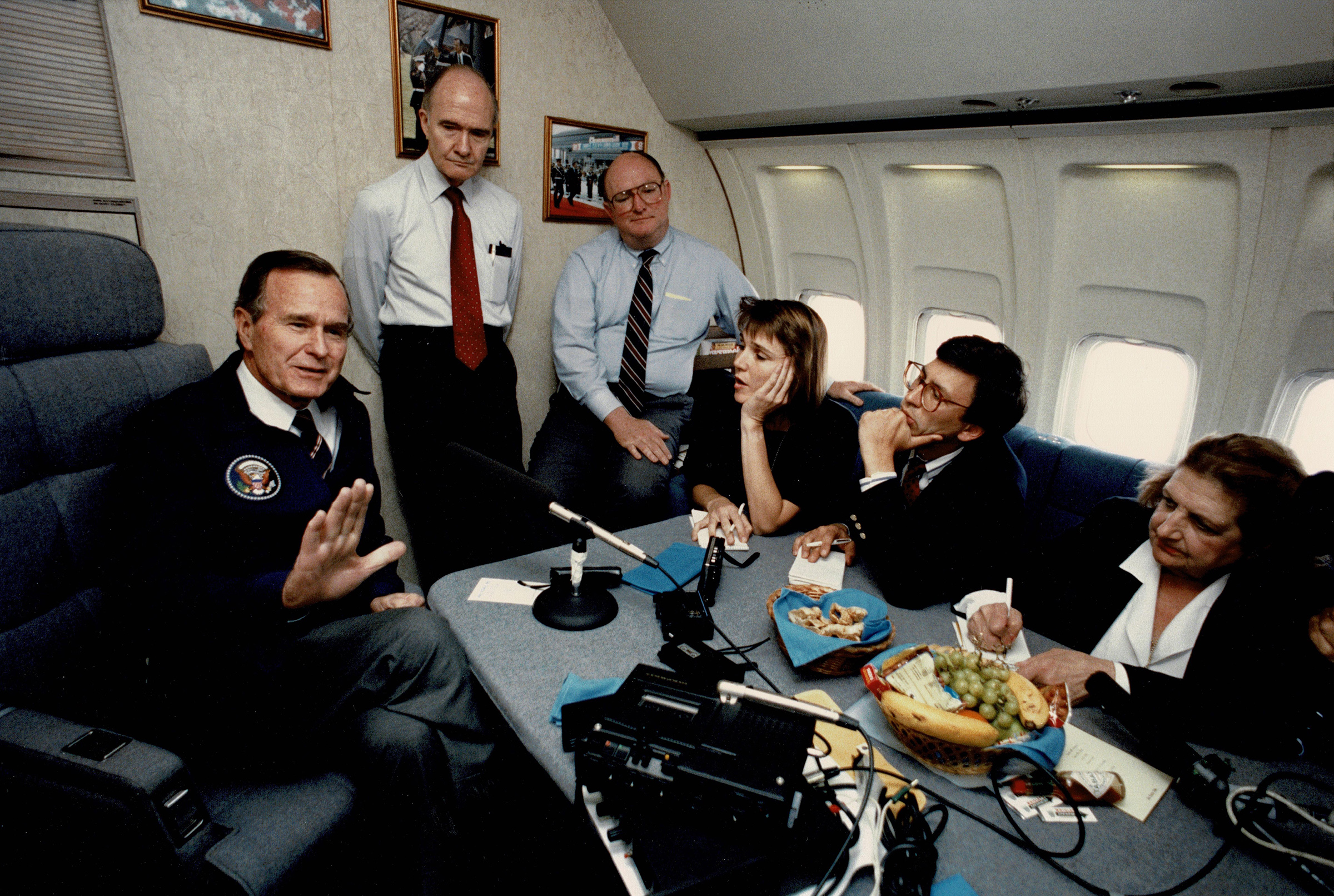 Frank Sesno, second from right, sits with other press, including White House press corps icon Helen Thomas (far right), interviewing then-President George H.W. Bush aboard Air Force One on May 13, 1989. (Photos courtesy Frank Sesno)